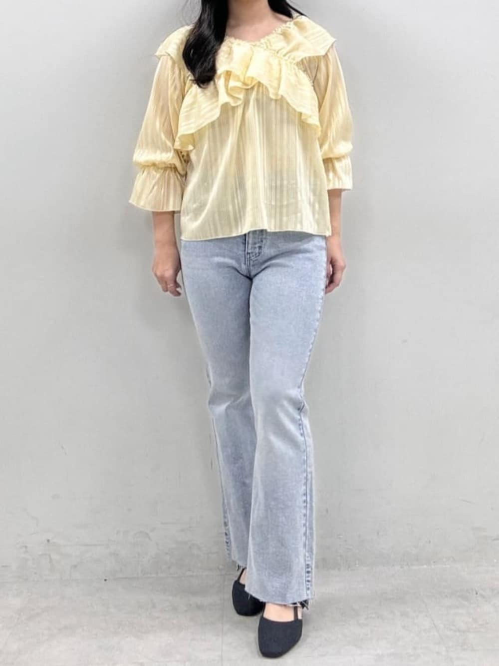 イエロー系のシャツ/ブラウス、ブルー系のデニムパンツを着用したレディースの冬コーディネートの4枚目の写真