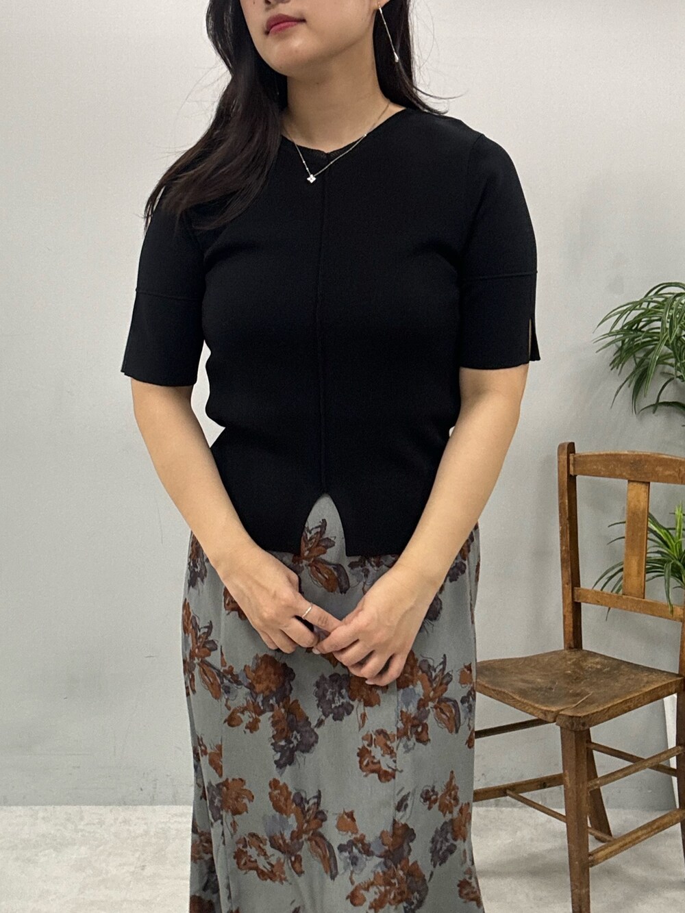 ブラウン系のショルダーバッグ、グレー系のスカート、ブラック系のニット/セーターを着用したレディースの春コーディネートの4枚目の写真