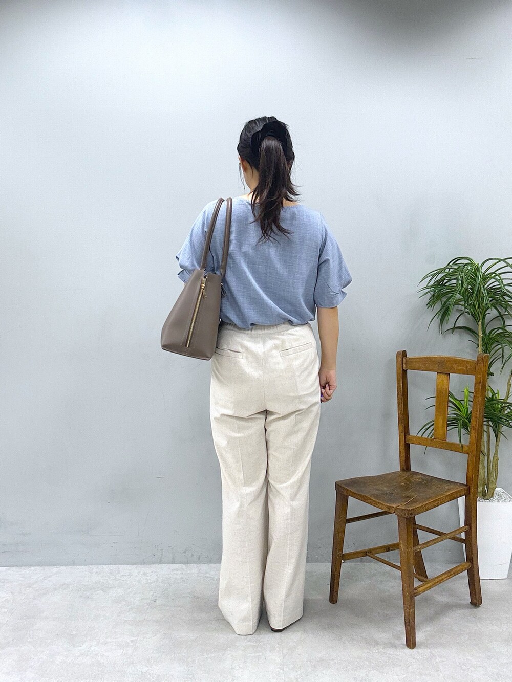 ブラウン系のショルダーバッグ、ベージュ系のその他パンツ、ブルー系のシャツ/ブラウスを着用したレディースの春コーディネートの3枚目の写真