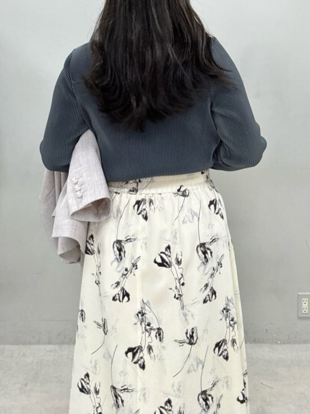 ホワイト系のスカート、グレー系のテーラードジャケット、グレー系のTシャツ/カットソーを着用したレディースの冬コーディネートの6枚目の写真