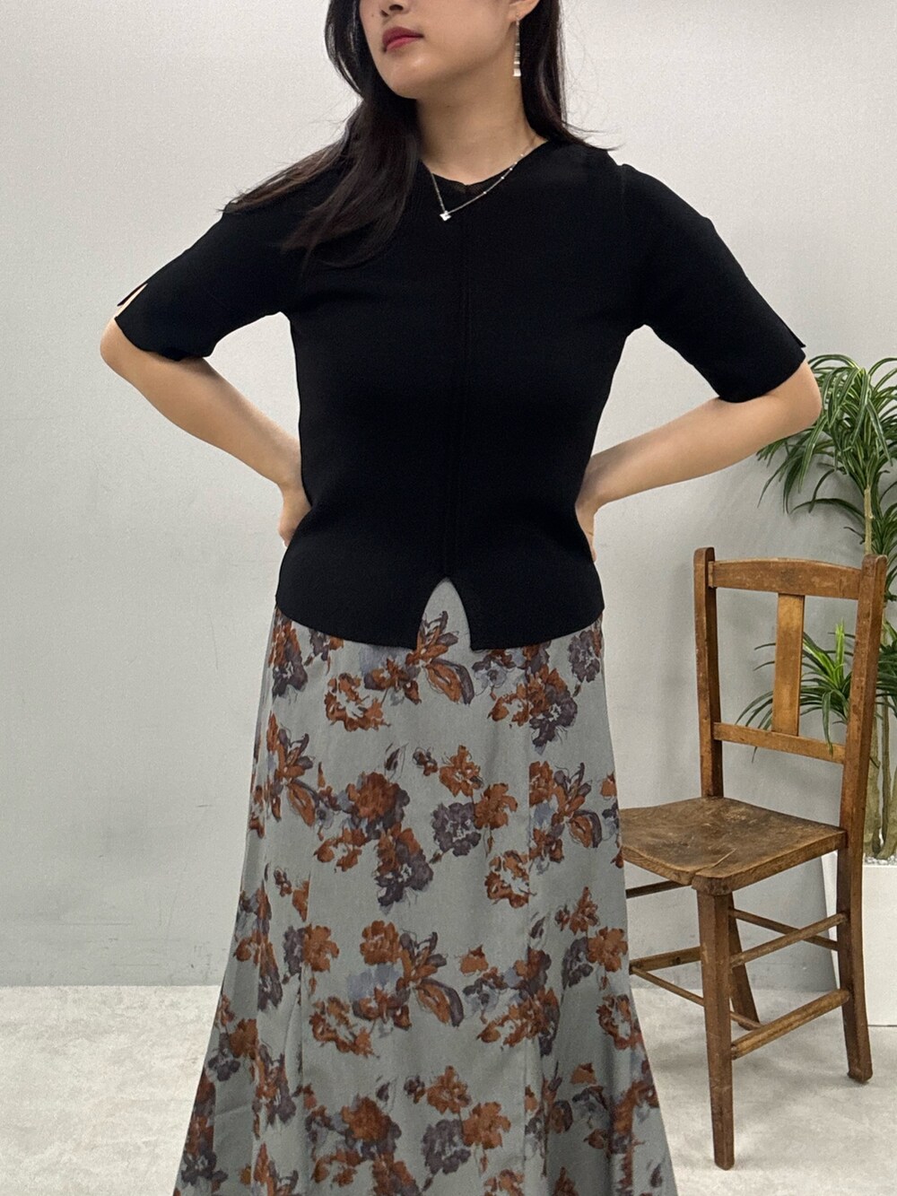 ブラウン系のショルダーバッグ、グレー系のスカート、ブラック系のニット/セーターを着用したレディースの春コーディネートの5枚目の写真