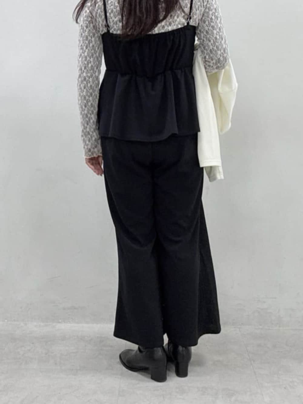 グレー系のTシャツ/カットソー、ブラック系のつなぎ/オールインワン、ホワイト系のカーディガン/ボレロを着用したレディースの冬コーディネートの5枚目の写真