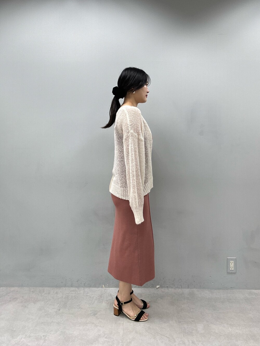 レッド系のワンピース、ホワイト系のカーディガン/ボレロを着用したレディースの春コーディネートの2枚目の写真