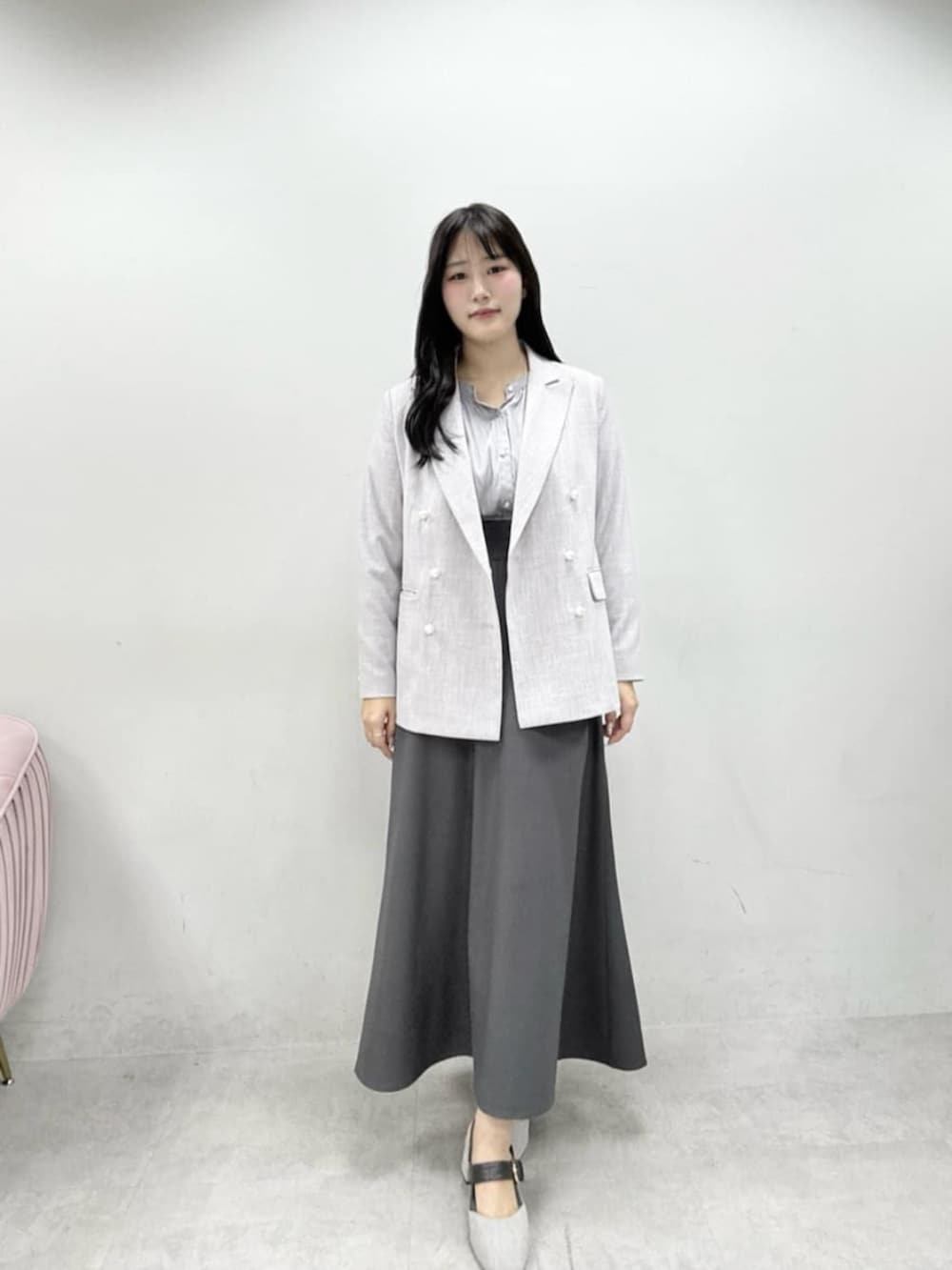 ホワイト系のテーラードジャケット、ホワイト系のハンドバッグ、グレー系のサンダルを着用したレディースの春コーディネートの2枚目の写真