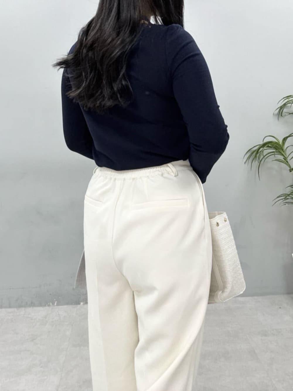 グレー系のテーラードジャケット、ホワイト系のハンドバッグ、ホワイト系のスラックスを着用したレディースの春コーディネートの7枚目の写真