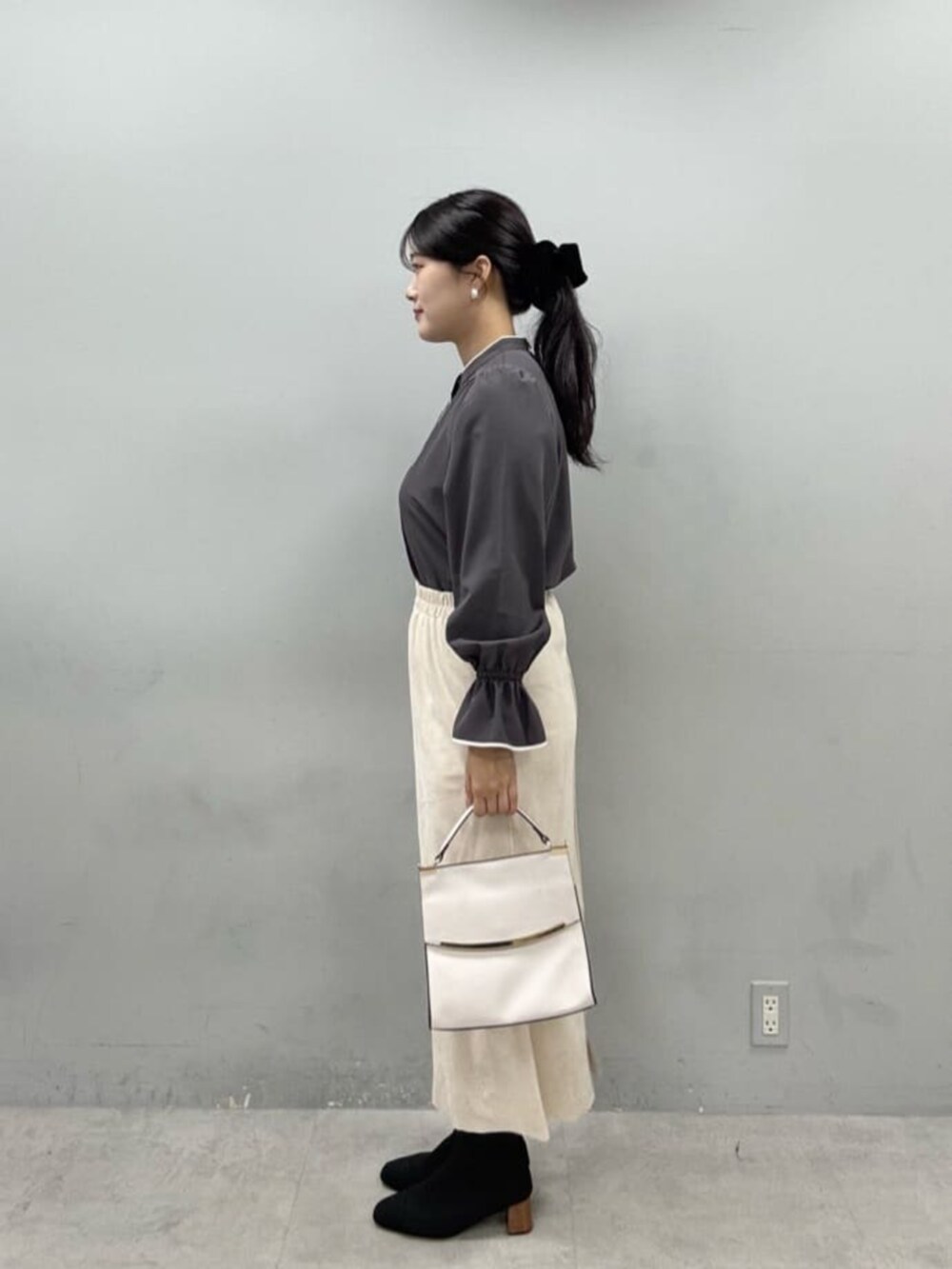 グレー系のシャツ/ブラウス、ベージュ系のスカート、ホワイト系のショルダーバッグを着用したレディースの秋コーディネートの2枚目の写真