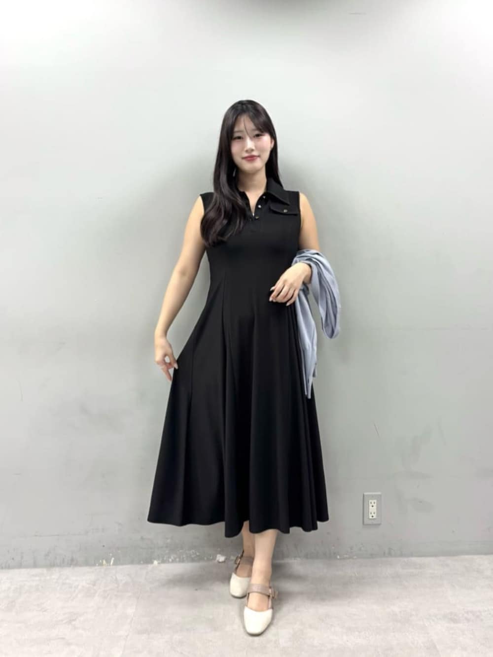 ブラック系のワンピースを着用したレディースの春コーディネートの2枚目の写真