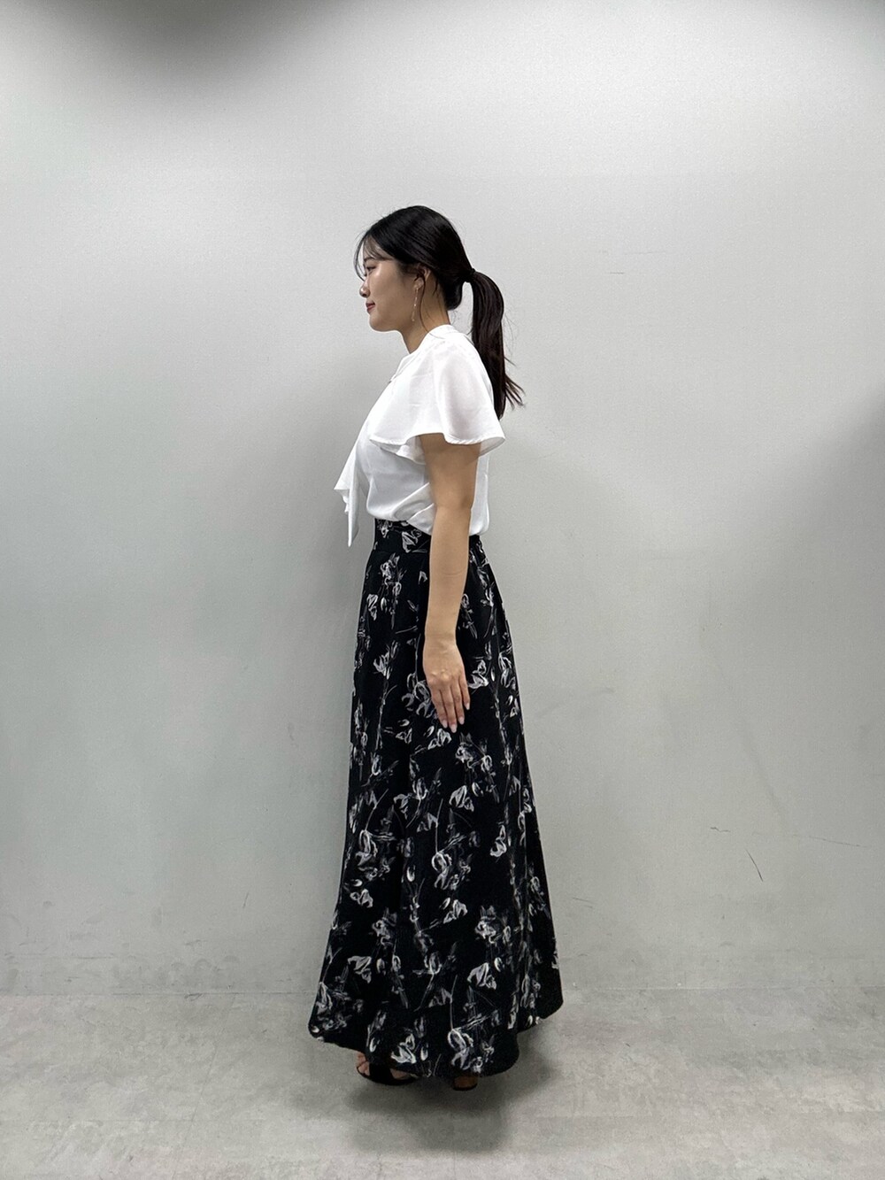 ブラック系のスカート、ホワイト系のシャツ/ブラウスを着用したレディースの春コーディネートの2枚目の写真