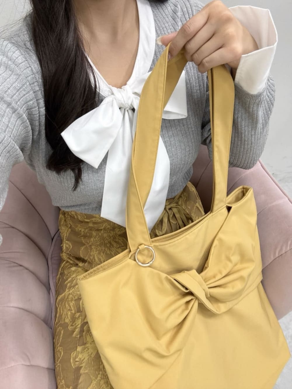 イエロー系のスカート、グレー系のニット/セーター、イエロー系のトートバッグを着用したレディースの冬コーディネートの4枚目の写真