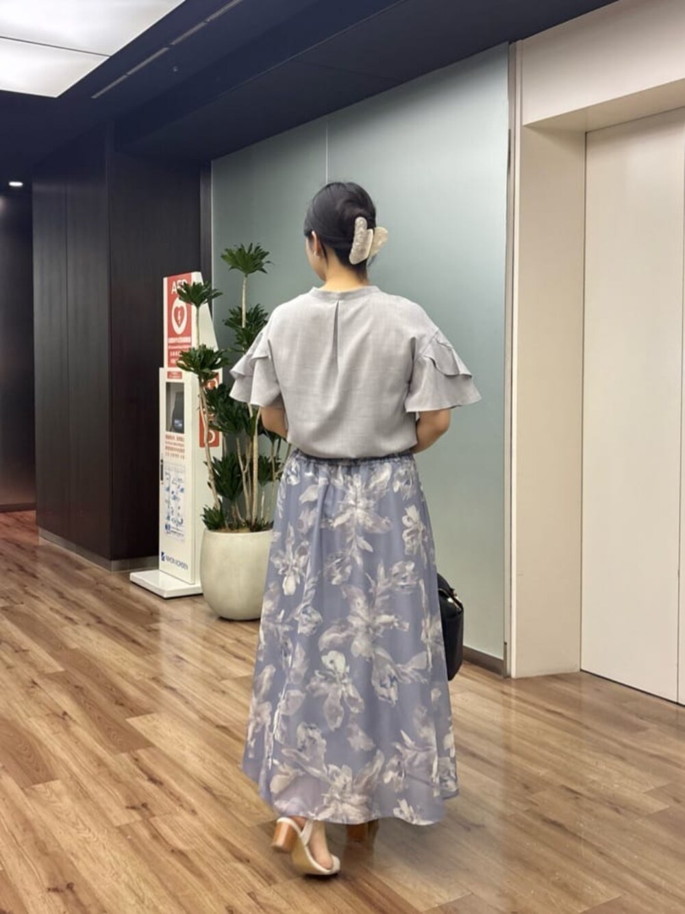 グレー系のシャツ/ブラウス、ブラック系のボストンバッグ、ブルー系のスカートを着用したレディースの夏コーディネートの4枚目の写真