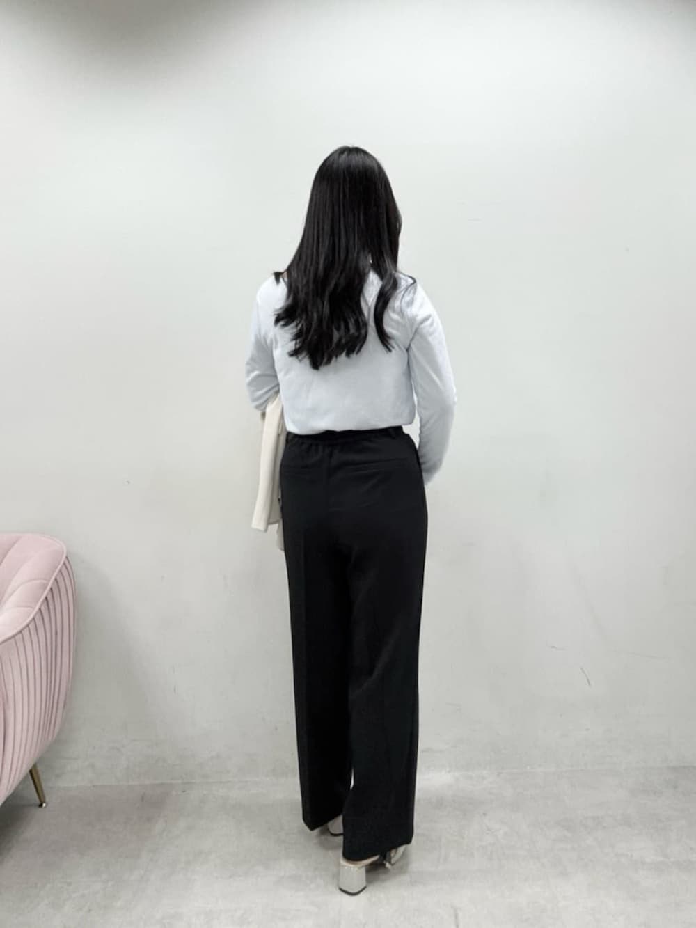 ホワイト系のテーラードジャケット、ホワイト系のハンドバッグ、グレー系のサンダルを着用したレディースの冬コーディネートの5枚目の写真