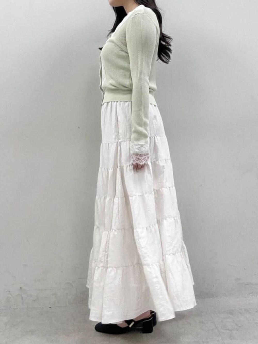 ホワイト系のスカート、グリーン系のカーディガン/ボレロを着用したレディースの冬コーディネートの2枚目の写真