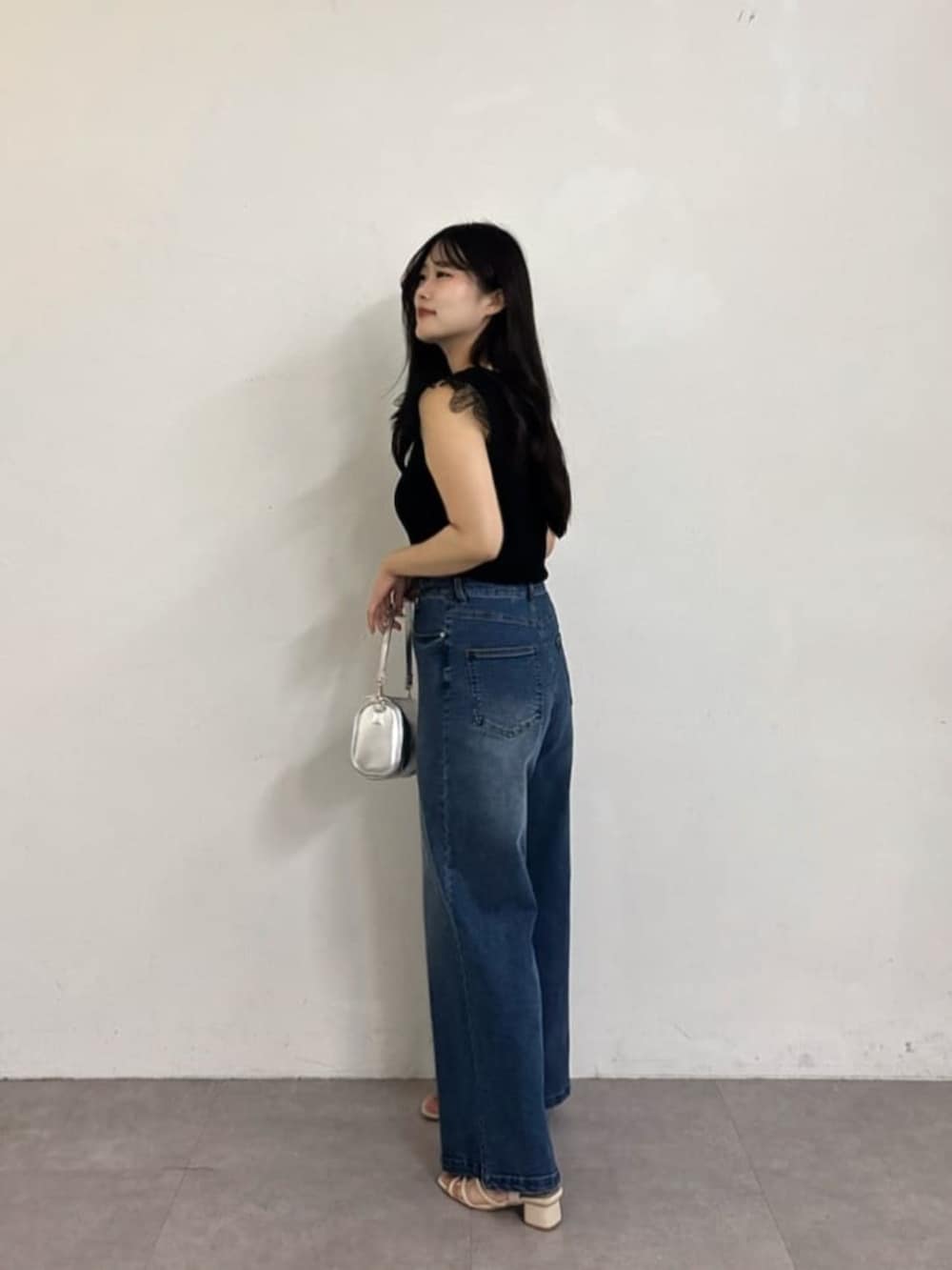 ブルー系のデニムパンツ、ブラック系のニット/セーターを着用したレディースの夏コーディネートの3枚目の写真
