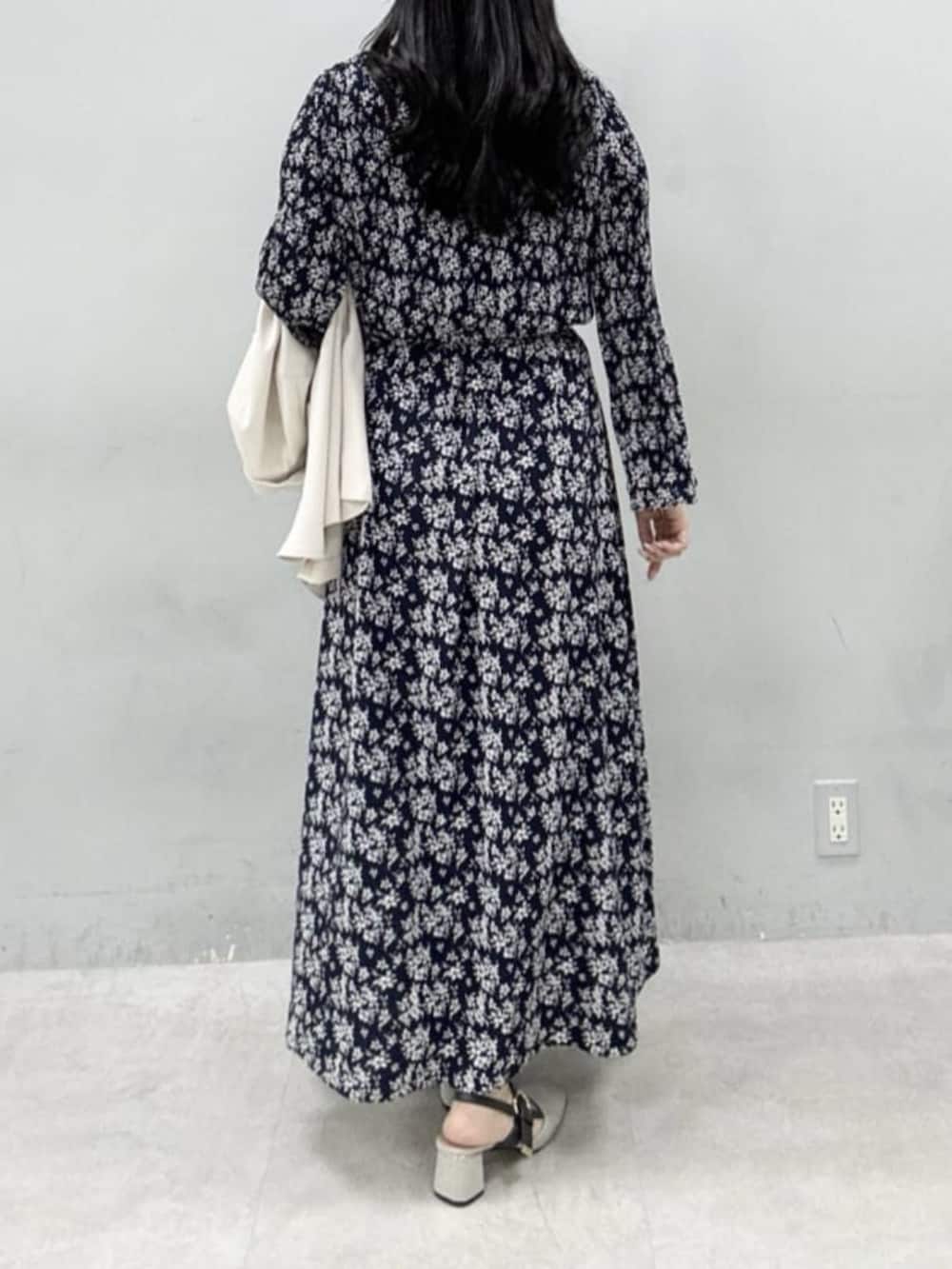 ホワイト系のテーラードジャケット、ホワイト系のハンドバッグ、グレー系のサンダルを着用したレディースの冬コーディネートの6枚目の写真