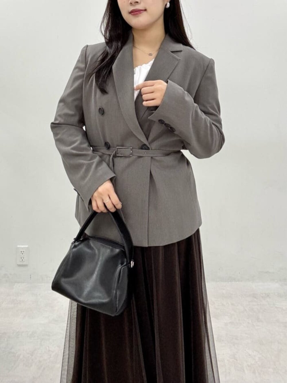 ブラウン系のスカート、グレー系のテーラードジャケットを着用したレディースの秋コーディネートの9枚目の写真