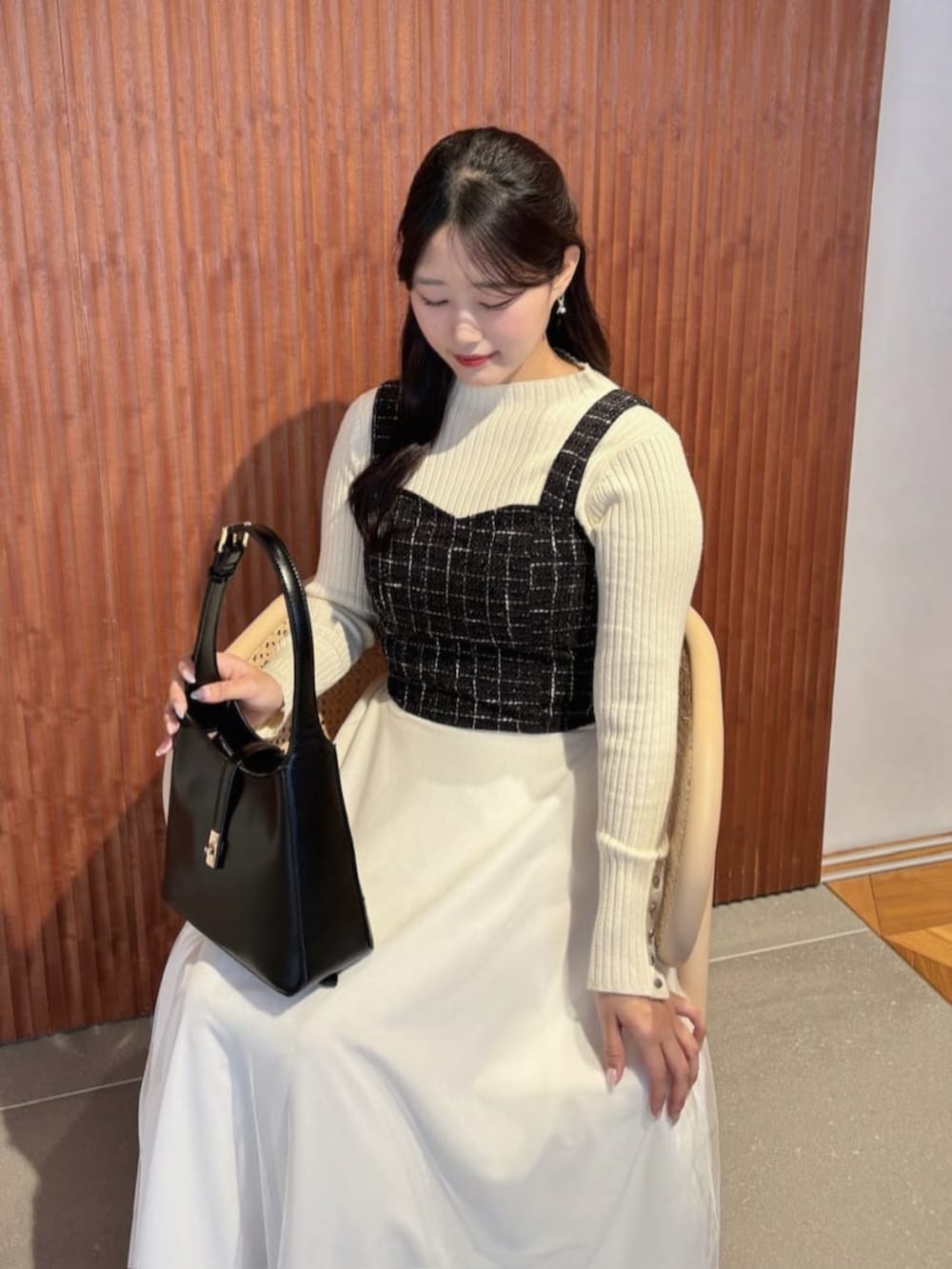 ホワイト系のスカート、ブラック系のシャツ/ブラウス、ホワイト系のニット/セーターを着用したレディースの秋コーディネートの5枚目の写真