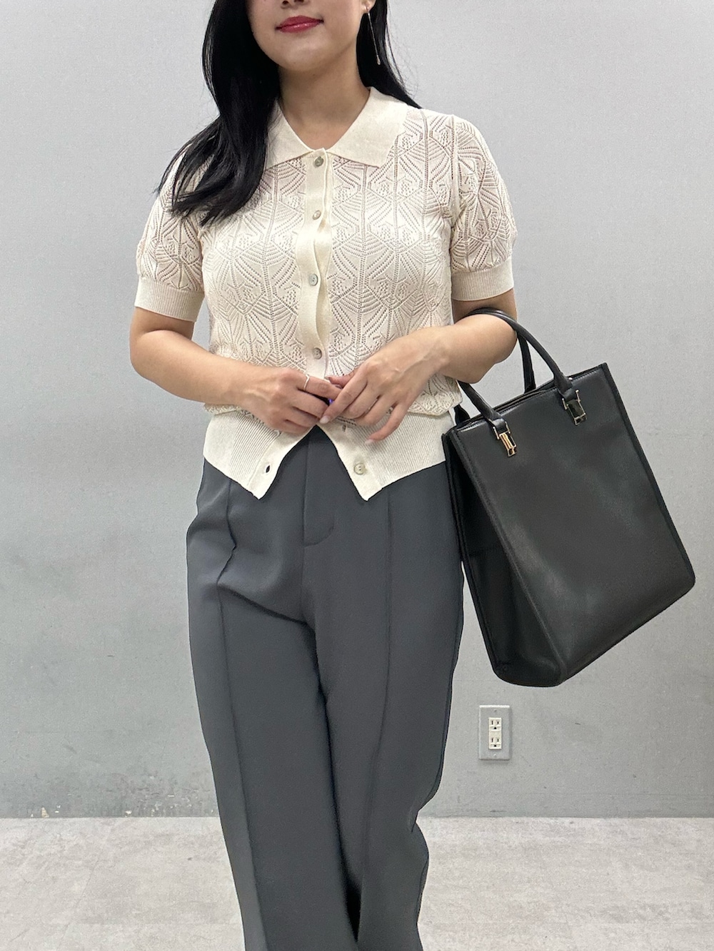 グレー系のその他パンツ、ホワイト系のニット/セーター、ブラック系のショルダーバッグを着用したレディースの春コーディネートの4枚目の写真