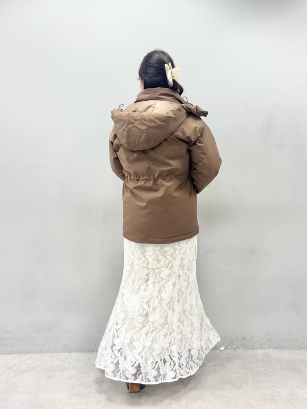 ホワイト系のニット/セーター、ブラウン系のダウンジャケット/コートを着用したレディースの秋コーディネートの6枚目の写真