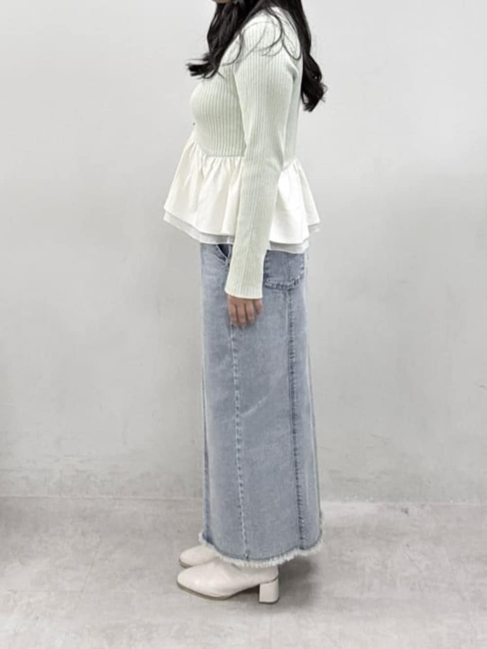 グリーン系のニット/セーター、ブルー系のデニムスカートを着用したレディースの冬コーディネートの2枚目の写真