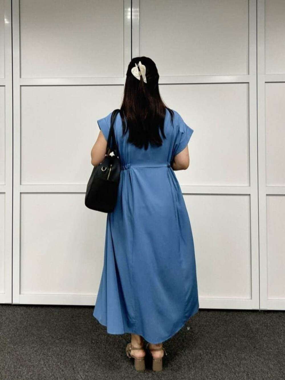 ブラック系のボストンバッグ、ブルー系のワンピース、ブルー系のカーディガン/ボレロを着用したレディースの秋コーディネートの4枚目の写真