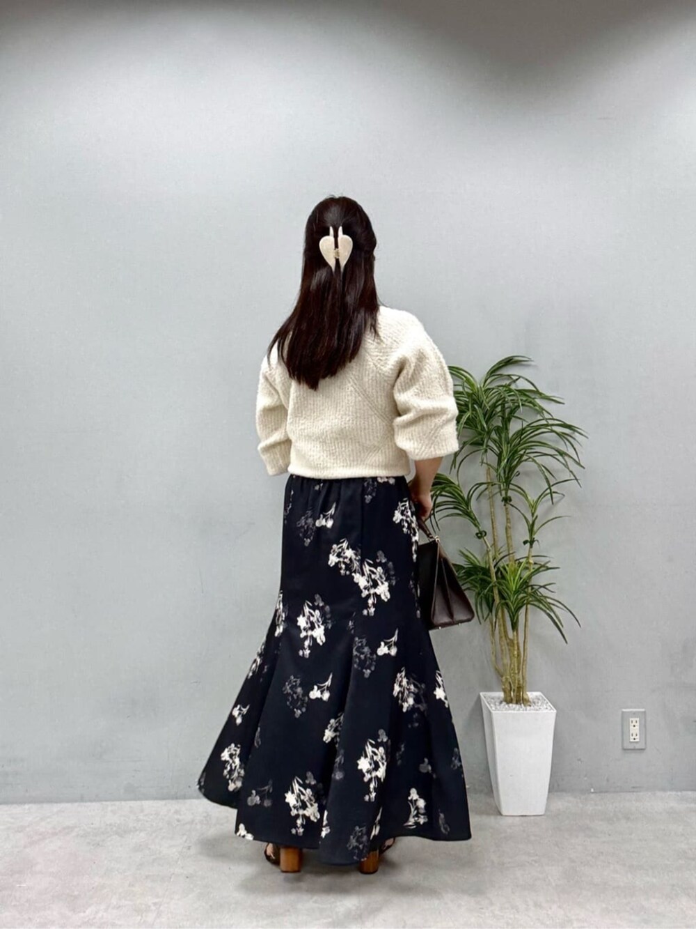 ホワイト系のニット/セーター、ブラック系のスカートを着用したレディースの夏コーディネートの3枚目の写真