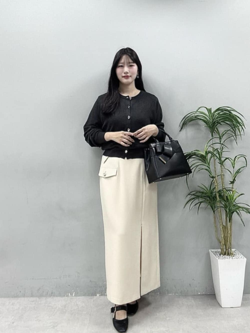 ホワイト系のスカート、ブルー系のシャツ/ブラウス、グレー系のカーディガン/ボレロを着用したレディースの春コーディネートの2枚目の写真