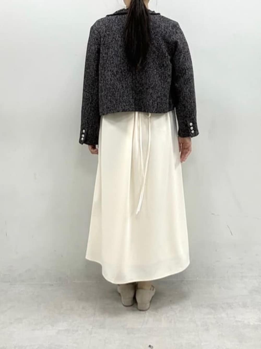 ブラック系のノーカラージャケット、ホワイト系のワンピースを着用したレディースの冬コーディネートの6枚目の写真