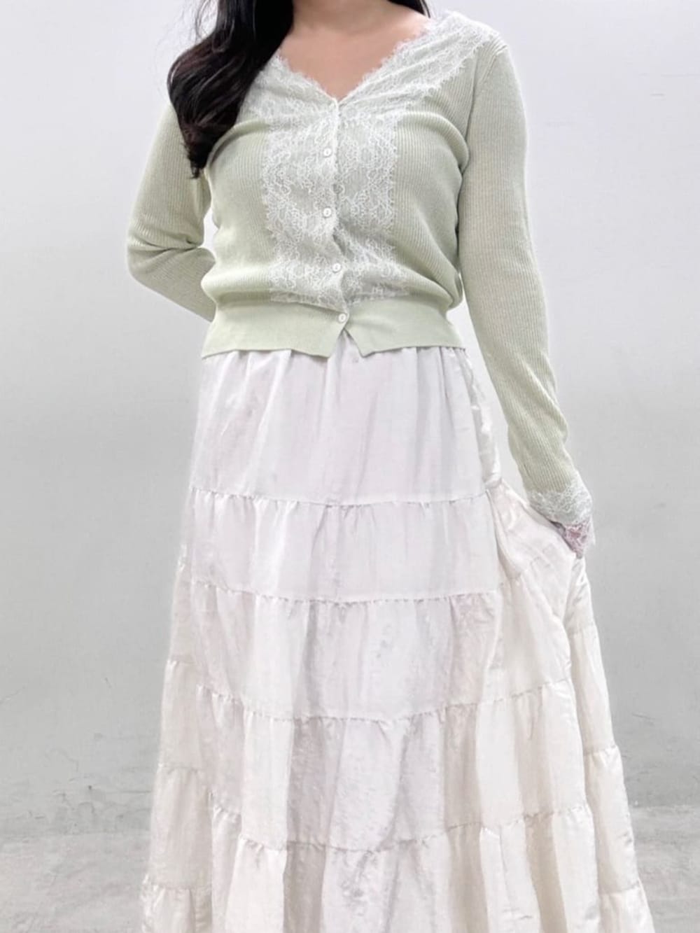 ホワイト系のスカート、グリーン系のカーディガン/ボレロを着用したレディースの冬コーディネートの3枚目の写真