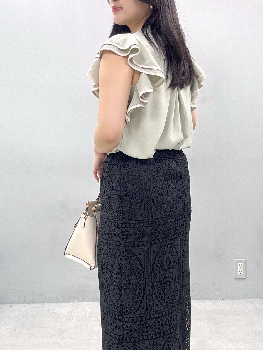 ブラック系のスカート、グリーン系のシャツ/ブラウスを着用したレディースの春コーディネートの5枚目の写真