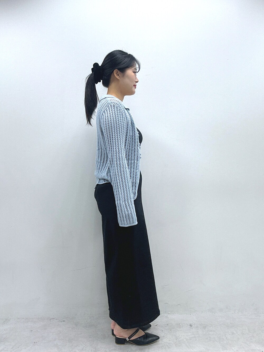 ブラック系のスカート、ブルー系のカーディガン/ボレロ、ブラウン系のショルダーバッグを着用したレディースの冬コーディネートの4枚目の写真