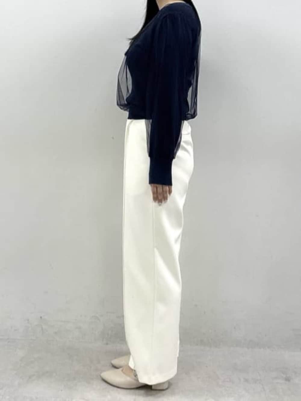 ホワイト系のスラックス、ブルー系のニット/セーターを着用したレディースの春コーディネートの2枚目の写真