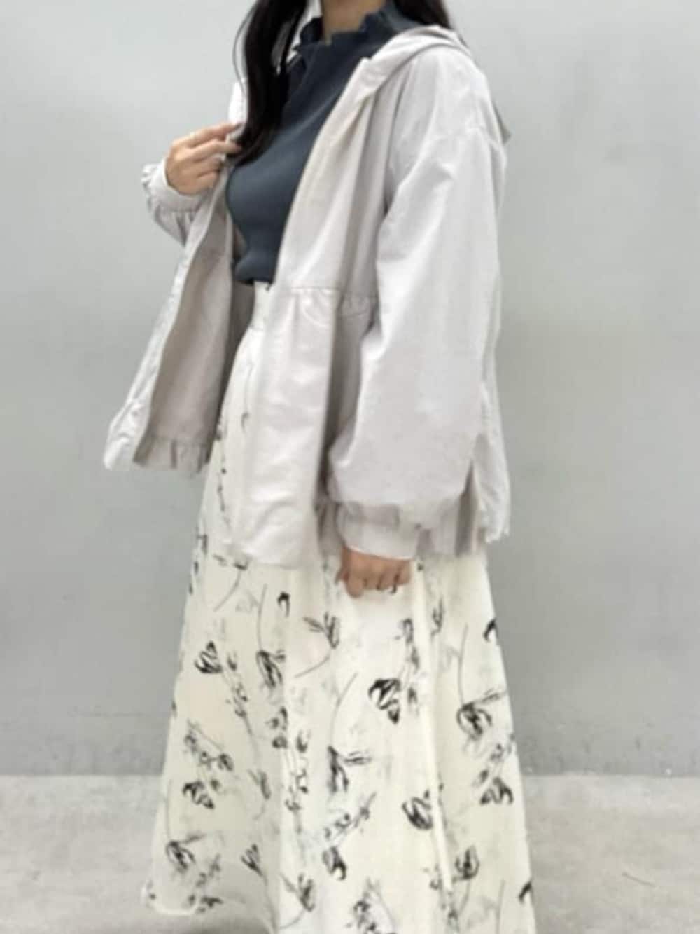 ホワイト系のスカート、グレー系のTシャツ/カットソー、グレー系のマウンテンパーカーを着用したレディースの冬コーディネートの3枚目の写真