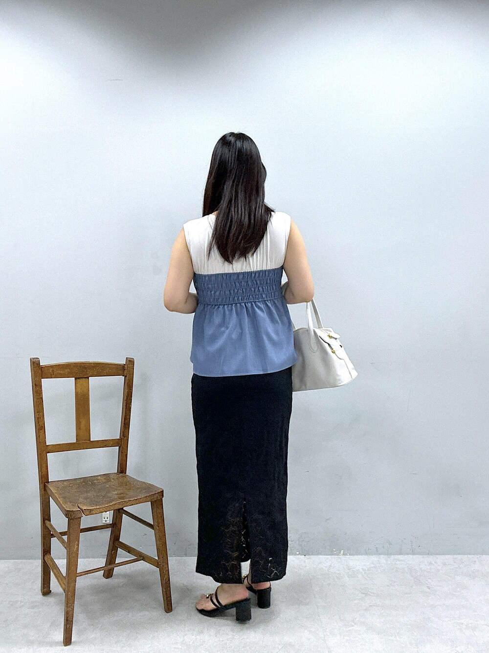 ブラック系のスカート、ブルー系のTシャツ/カットソー、ホワイト系のショルダーバッグを着用したレディースの春コーディネートの3枚目の写真