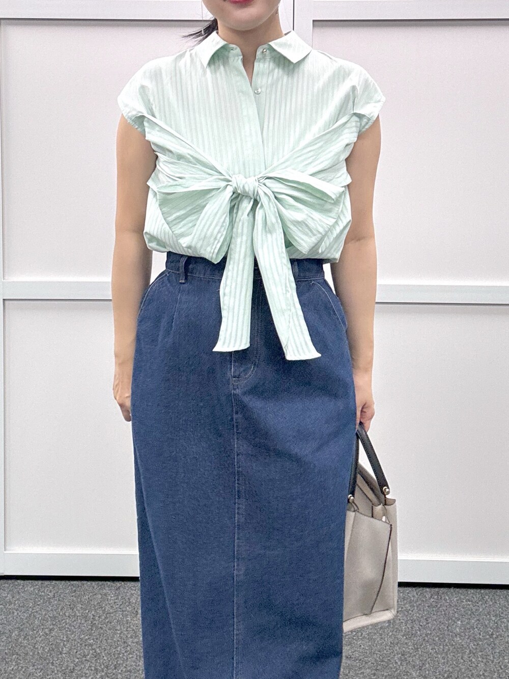 グレー系のショルダーバッグ、ブルー系のスカート、グリーン系のシャツ/ブラウスを着用したレディースの春コーディネートの3枚目の写真