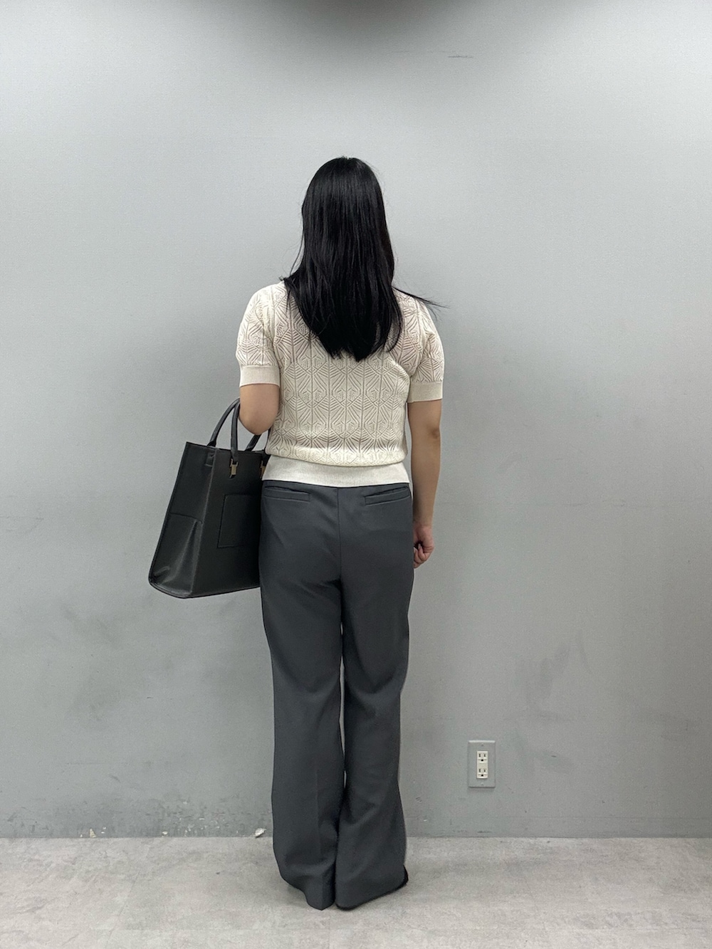 グレー系のその他パンツ、ホワイト系のニット/セーター、ブラック系のショルダーバッグを着用したレディースの春コーディネートの3枚目の写真