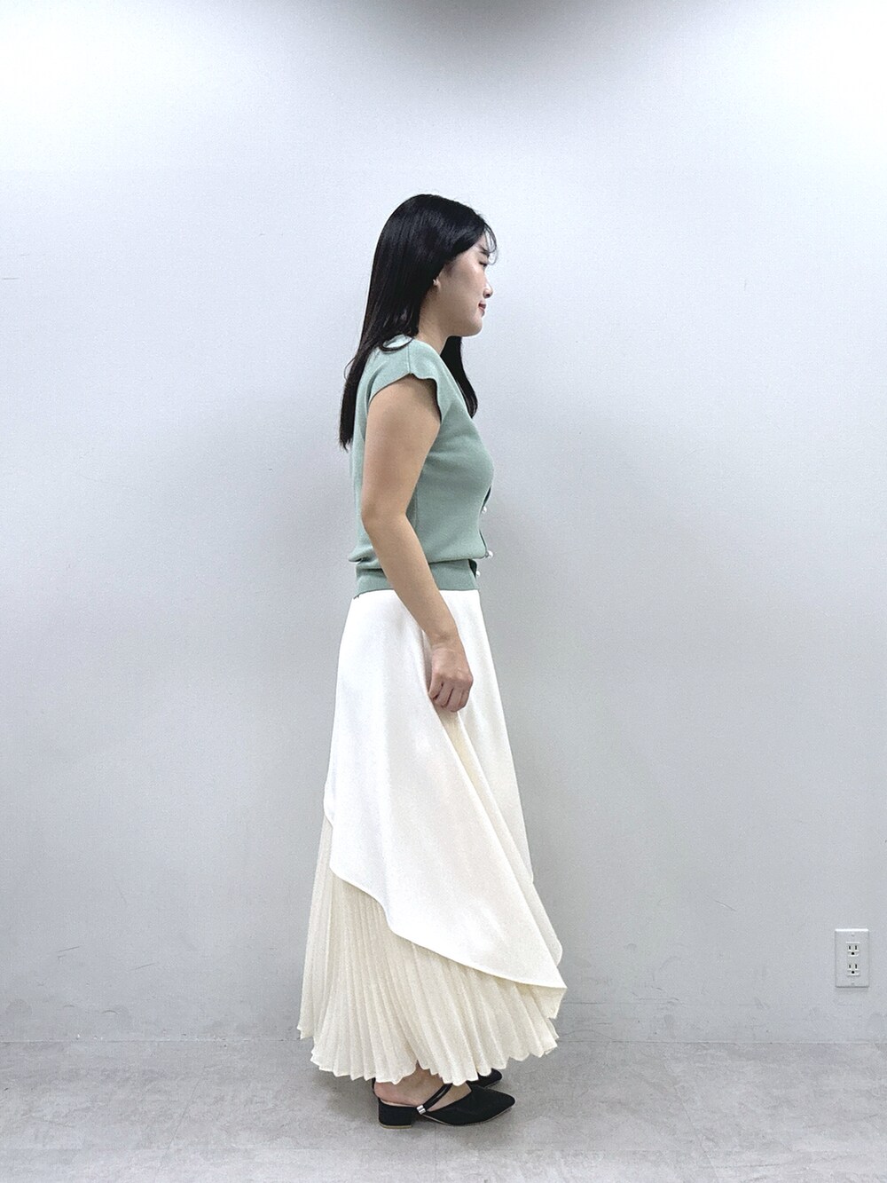 ホワイト系のスカート、グリーン系のニット/セーターを着用したレディースの春コーディネートの2枚目の写真