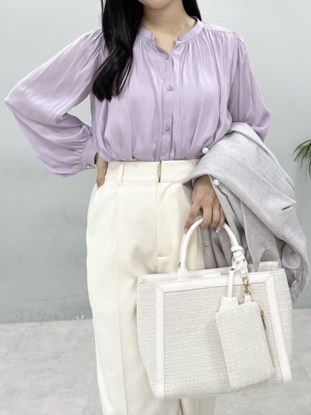 ホワイト系のハンドバッグ、パープル系のシャツ/ブラウス、ホワイト系のスラックスを着用したレディースの冬コーディネートの6枚目の写真