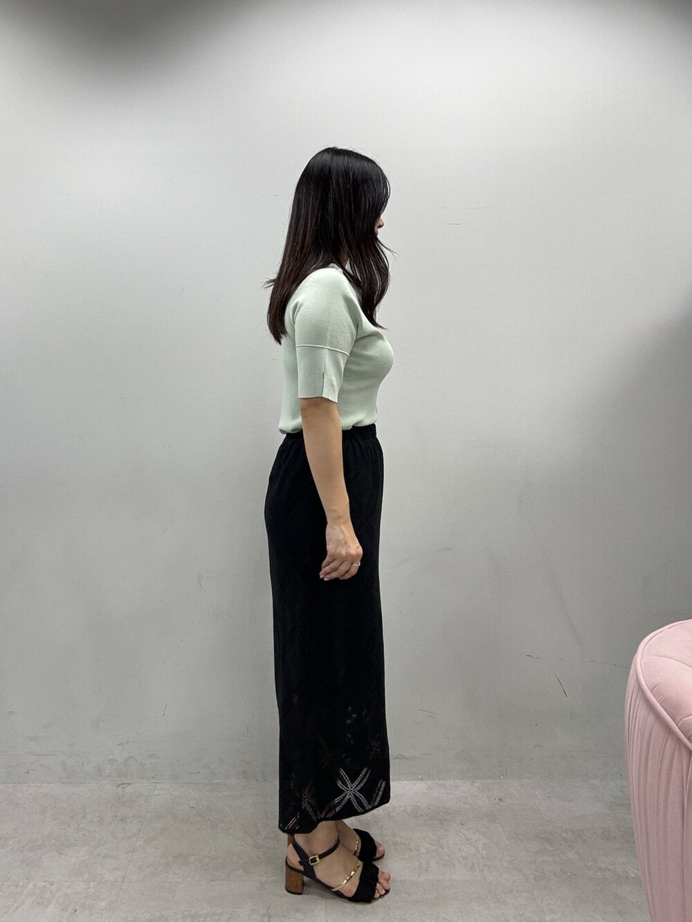 ホワイト系のショルダーバッグ、ブラック系のスカート、グリーン系のニット/セーターを着用したレディースの春コーディネートの2枚目の写真