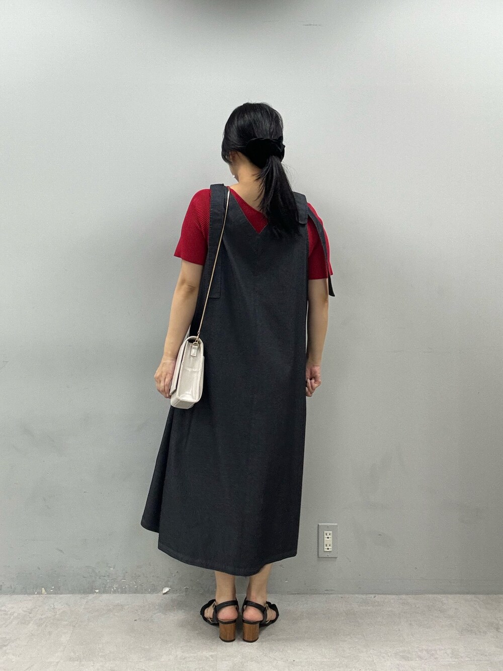 ホワイト系のショルダーバッグ、レッド系のニット/セーター、ブラック系のワンピースを着用したレディースの春コーディネートの3枚目の写真