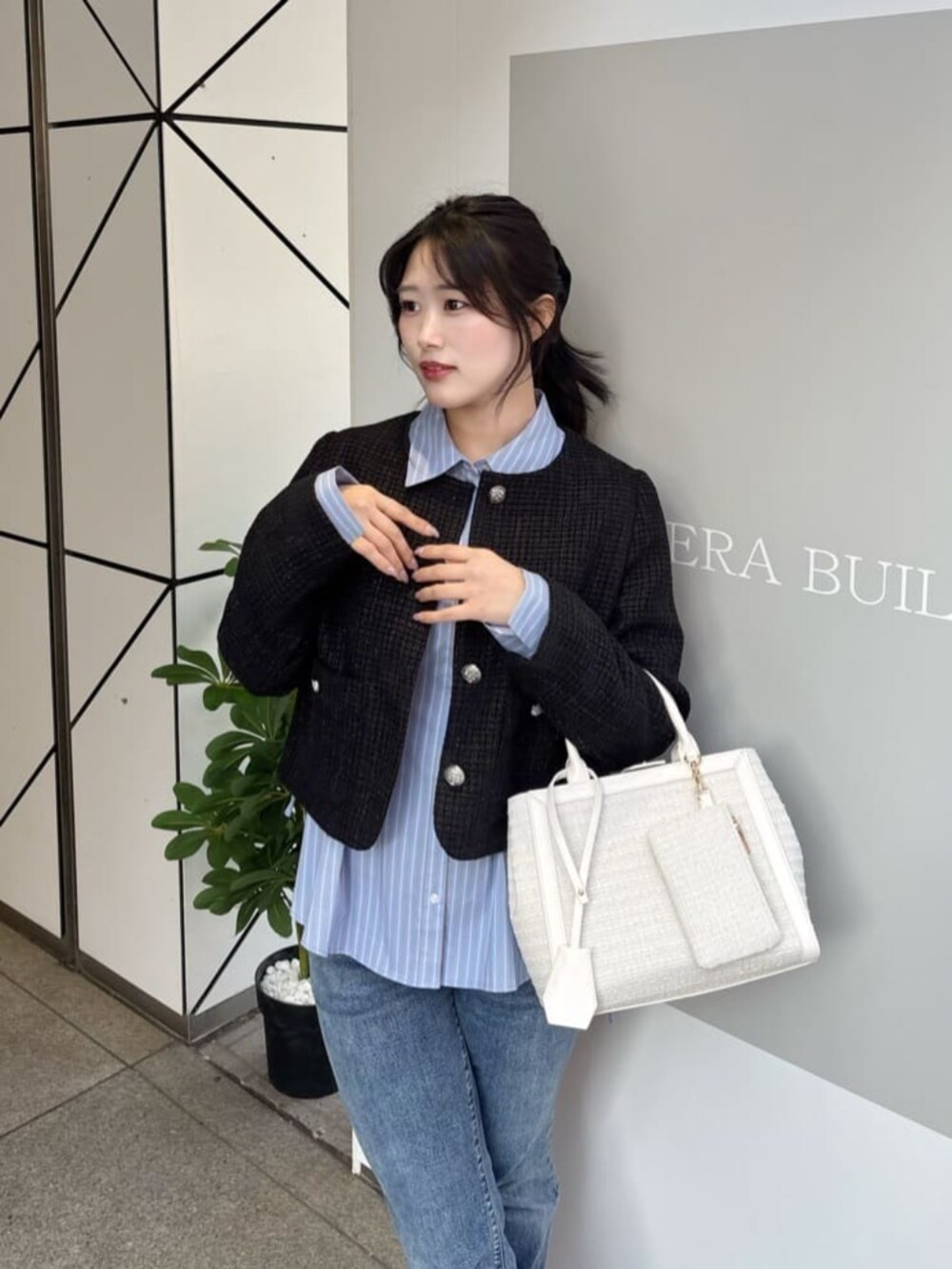 ブルー系のシャツ/ブラウス、ホワイト系のハンドバッグを着用したレディースの冬コーディネートの4枚目の写真