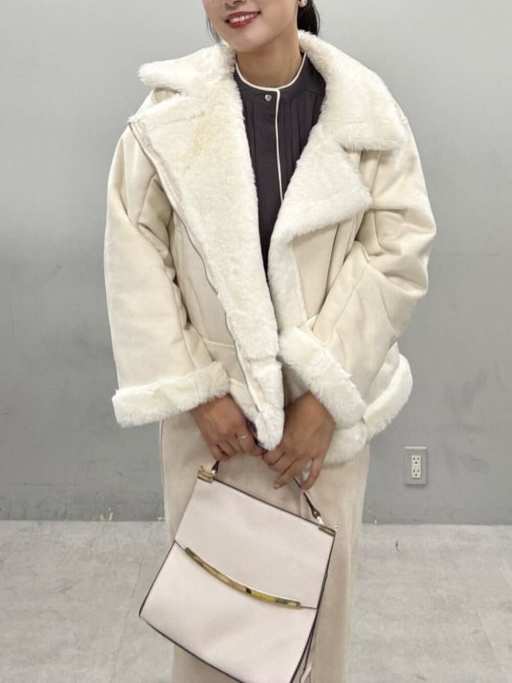 グレー系のシャツ/ブラウス、ベージュ系のスカート、ホワイト系のブルゾンを着用したレディースの秋コーディネートの5枚目の写真