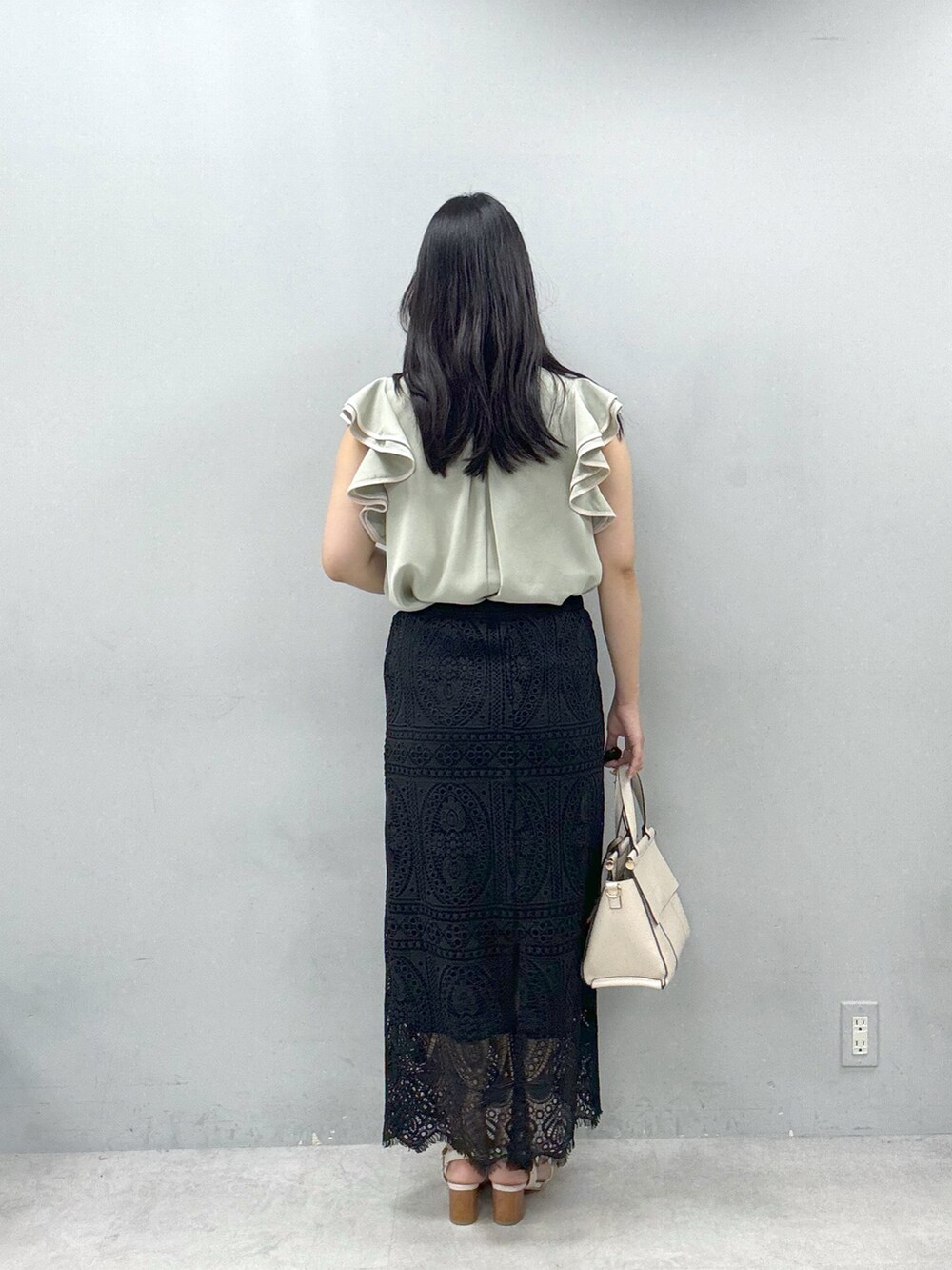 ブラック系のスカート、グリーン系のシャツ/ブラウスを着用したレディースの春コーディネートの3枚目の写真