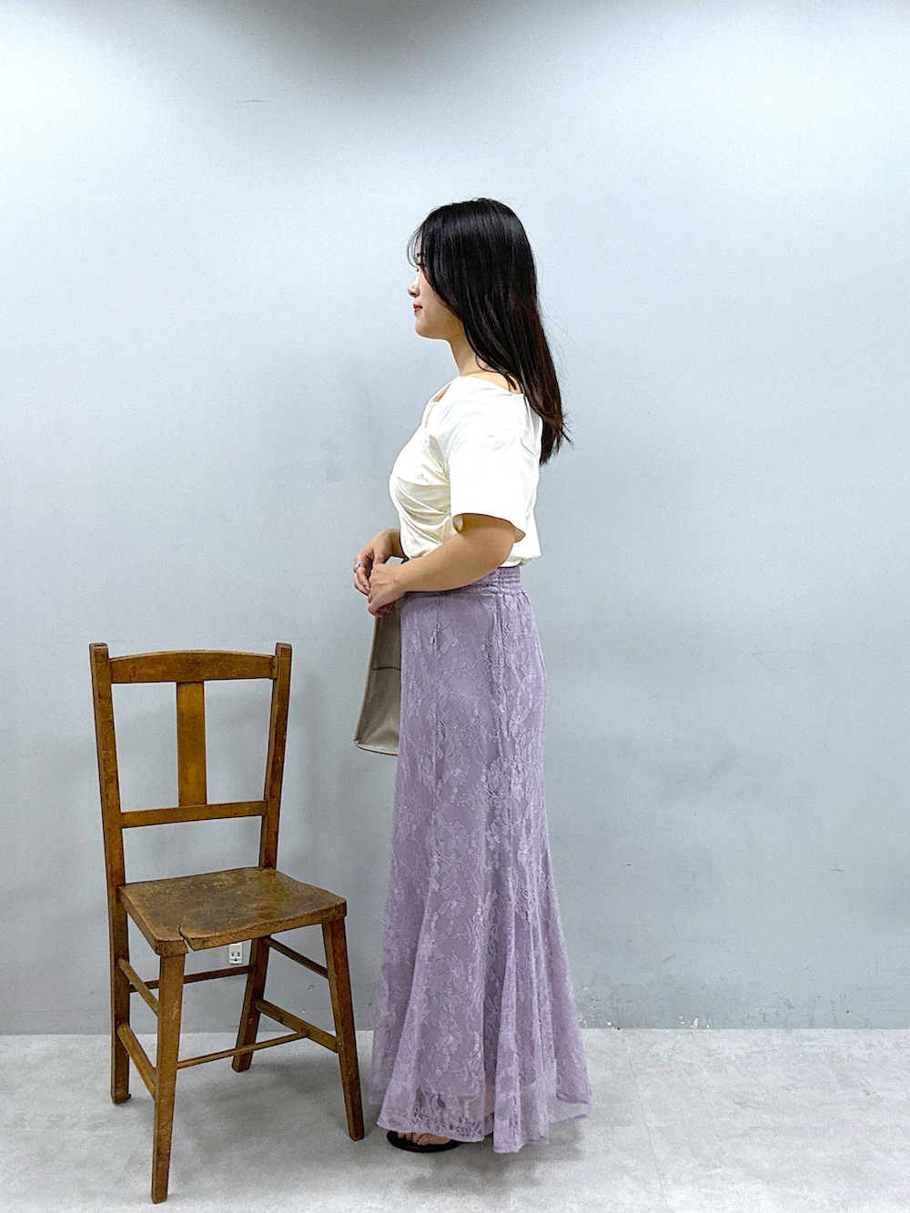 ベージュ系のショルダーバッグ、パープル系のスカート、ホワイト系のTシャツ/カットソーを着用したレディースの春コーディネートの2枚目の写真