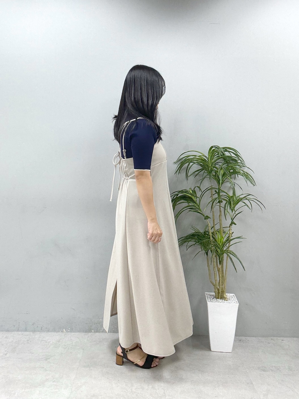 ベージュ系のワンピース、ブルー系のニット/セーター、ブラック系のショルダーバッグを着用したレディースの春コーディネートの2枚目の写真