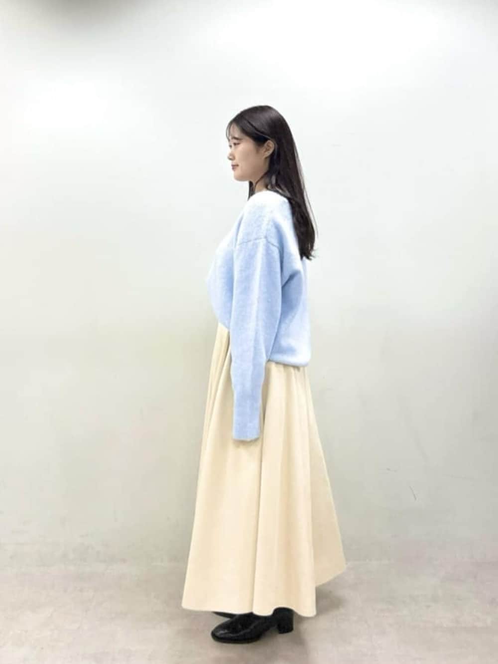 ホワイト系のスカート、ブルー系のニット/セーターを着用したレディースの秋コーディネートの2枚目の写真