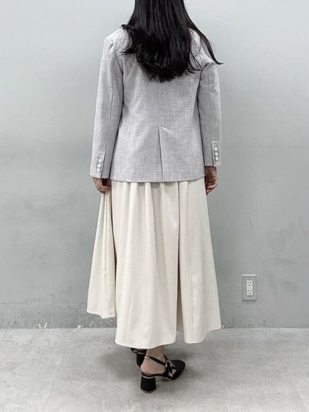 グレー系のテーラードジャケット、ホワイト系のワンピース、ブルー系のTシャツ/カットソーを着用したレディースの春コーディネートの3枚目の写真