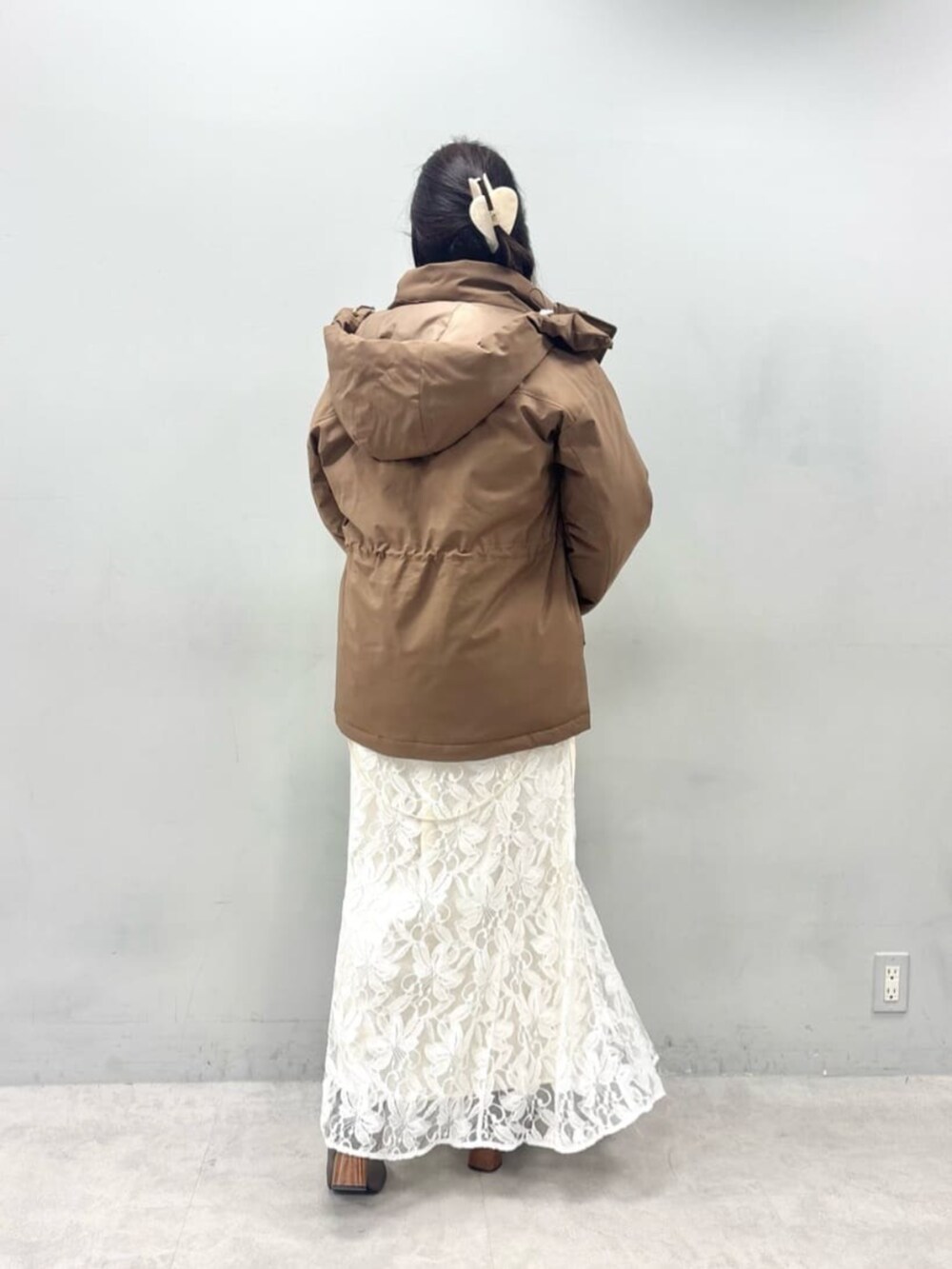 ホワイト系のニット/セーター、ブラウン系のダウンジャケット/コートを着用したレディースの秋コーディネートの3枚目の写真