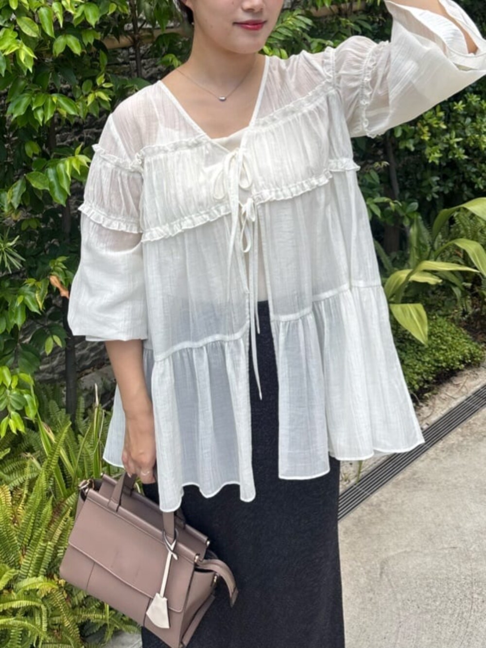 ブラック系のスカート、ホワイト系のシャツ/ブラウスを着用したレディースの夏コーディネートの6枚目の写真