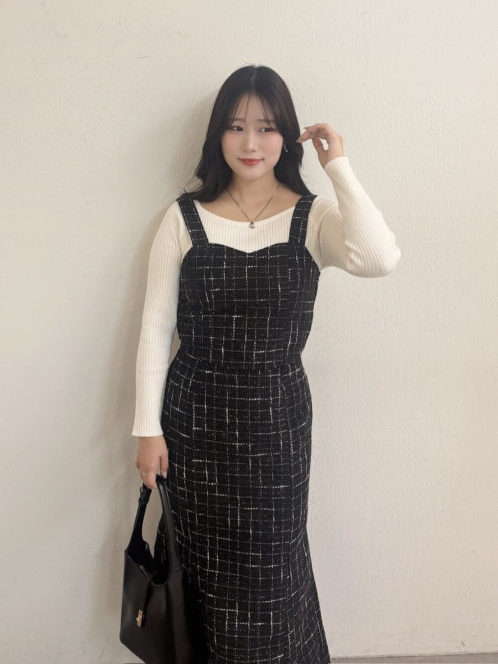 ブラック系のスカート、ブラック系のシャツ/ブラウス、ホワイト系のニット/セーターを着用したレディースの秋コーディネートの2枚目の写真