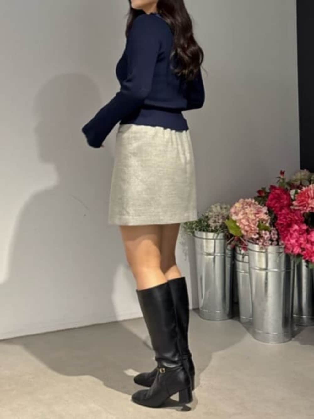 グレー系のスカート、ブルー系のニット/セーターを着用したレディースの冬コーディネートの2枚目の写真